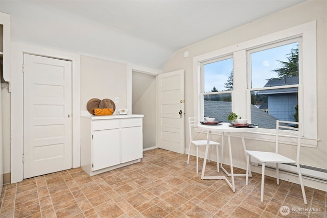 interior space featuring vaulted ceiling, white cabinets, and light countertops