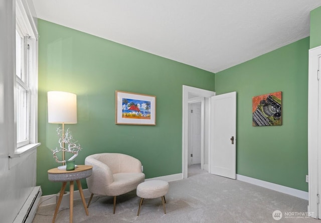 sitting room featuring baseboard heating, carpet, and baseboards