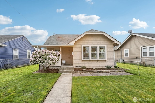 view of front of house featuring a front yard, fence, central AC, and a shingled roof