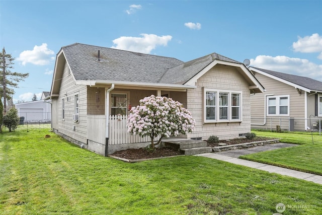 view of front of home with a front lawn, fence, and roof with shingles