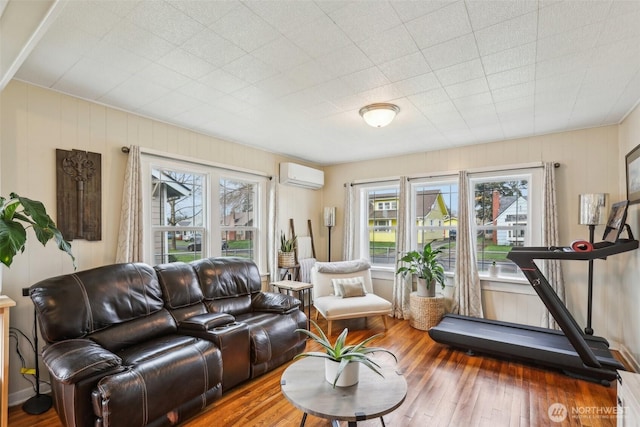 living area featuring an AC wall unit and hardwood / wood-style flooring