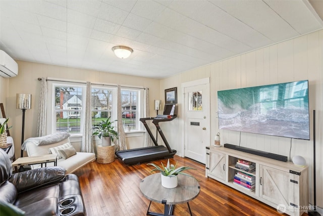 living room with a wall mounted AC and wood-type flooring