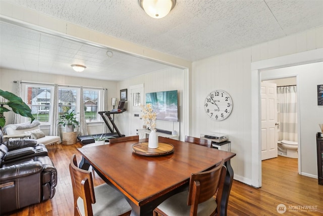 dining space with hardwood / wood-style floors and baseboards