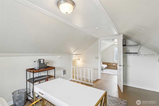 home office with vaulted ceiling and wood finished floors