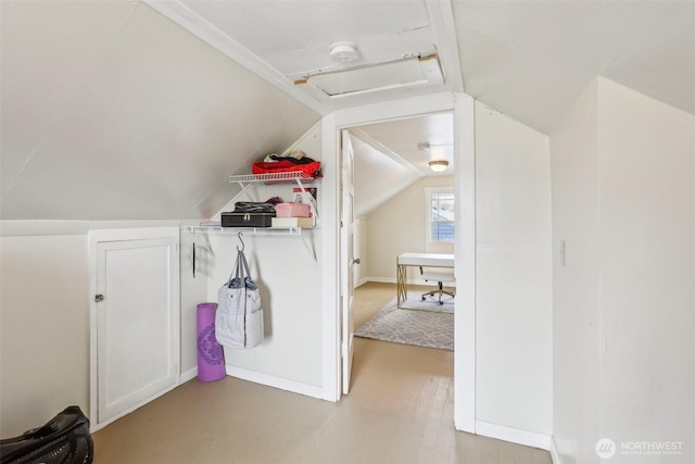 bonus room with light wood-type flooring, baseboards, and vaulted ceiling