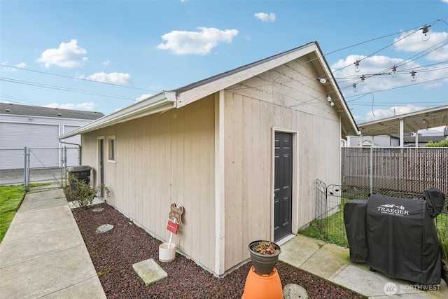 view of outdoor structure with cooling unit, fence, and a gate