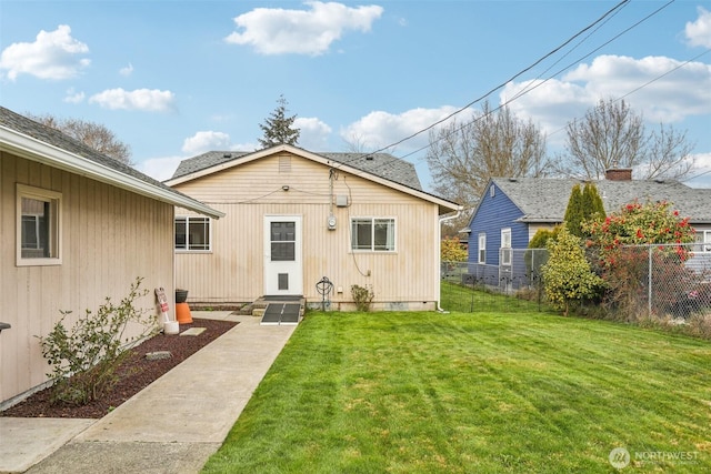 rear view of house with crawl space, a yard, and fence