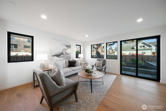 living area with baseboards, light wood-style flooring, and recessed lighting