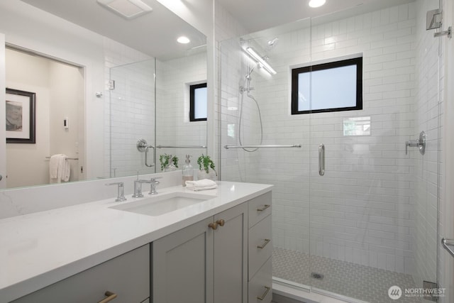 bathroom featuring a stall shower, vanity, and recessed lighting