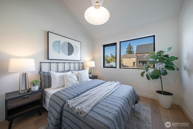 bedroom featuring vaulted ceiling, wood finished floors, and baseboards