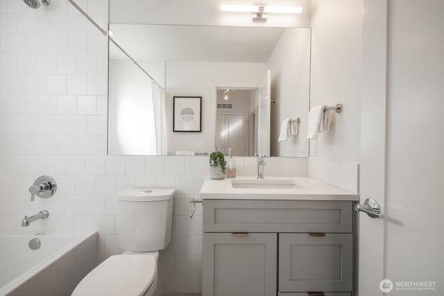 full bath with shower / bath combination, visible vents, toilet, vanity, and tile walls