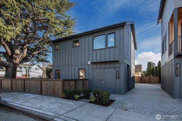 view of side of property with board and batten siding and fence