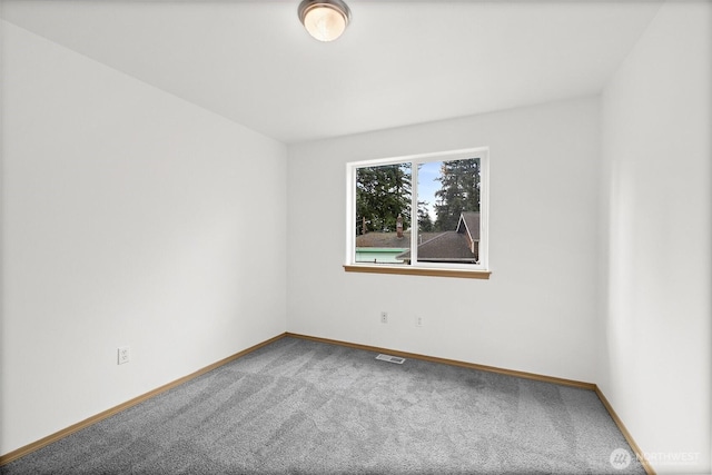 carpeted empty room featuring visible vents and baseboards