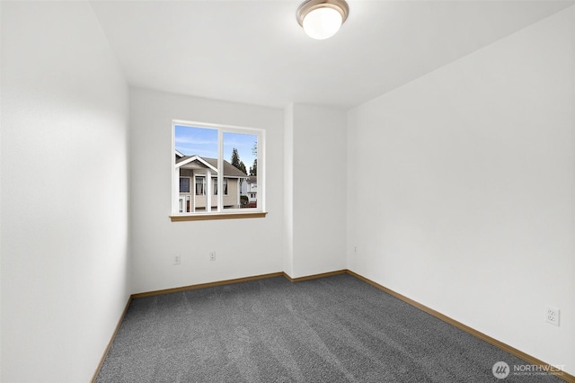 carpeted empty room featuring baseboards