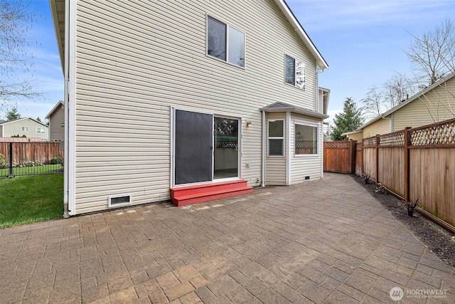 rear view of property with a fenced backyard and a patio area