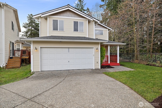 traditional-style house with a garage, driveway, a front lawn, and fence