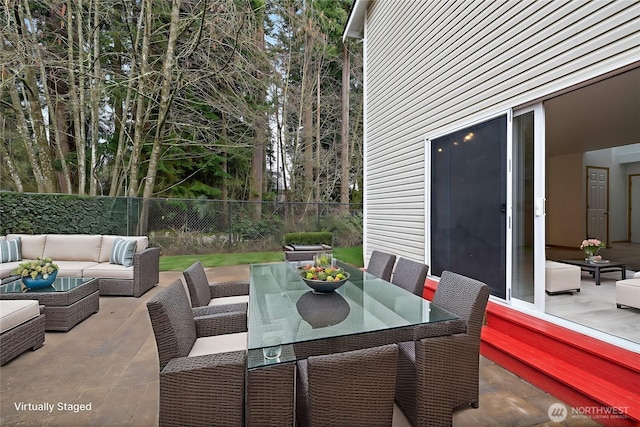 view of patio / terrace featuring an outdoor living space, outdoor dining area, and fence