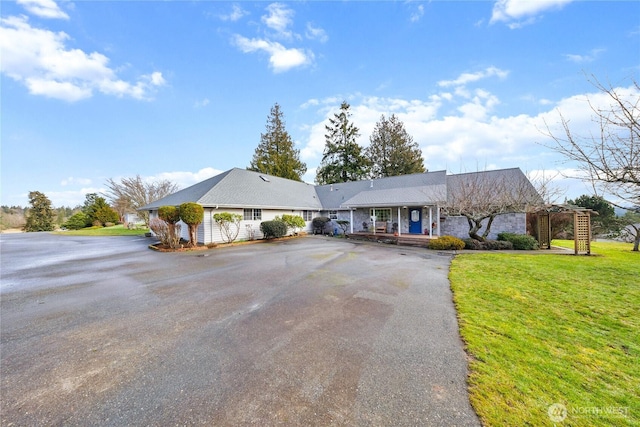 ranch-style home with aphalt driveway and a front yard