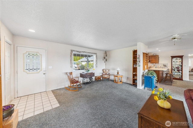 interior space with light colored carpet, ceiling fan, light tile patterned flooring, a textured ceiling, and recessed lighting