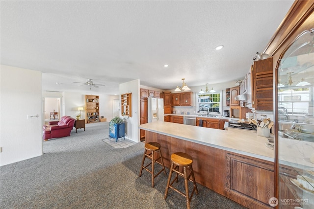 kitchen featuring carpet floors, white refrigerator with ice dispenser, light countertops, ceiling fan, and a peninsula