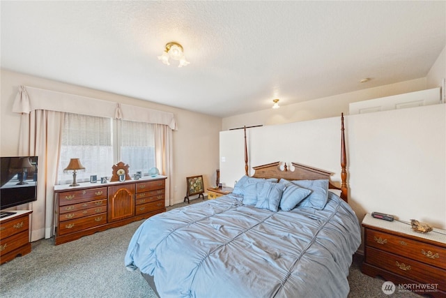 bedroom with a textured ceiling and light colored carpet