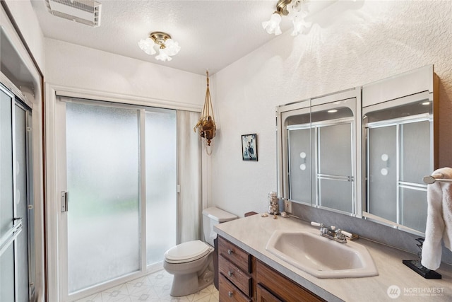 bathroom featuring visible vents, toilet, a textured ceiling, a shower stall, and vanity