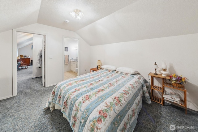 bedroom featuring a textured ceiling, ensuite bathroom, carpet floors, baseboards, and vaulted ceiling