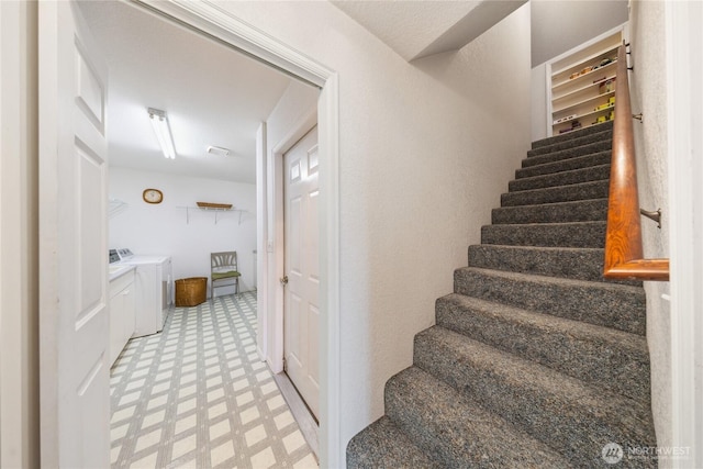 stairs featuring tile patterned floors and independent washer and dryer