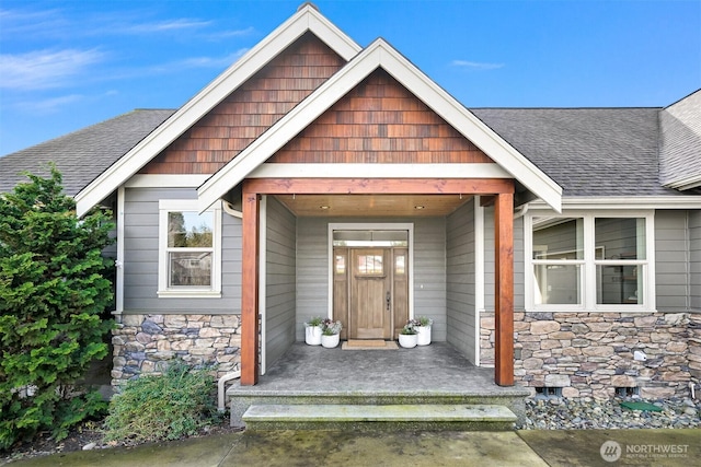 property entrance featuring a porch, stone siding, and roof with shingles