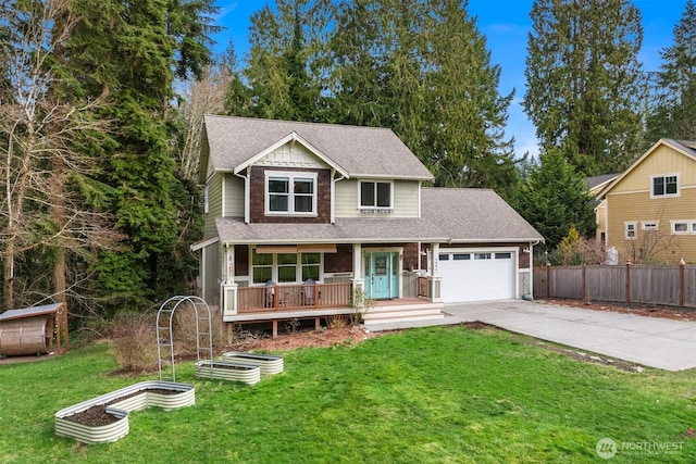 traditional-style house featuring an attached garage, fence, driveway, a vegetable garden, and a front lawn