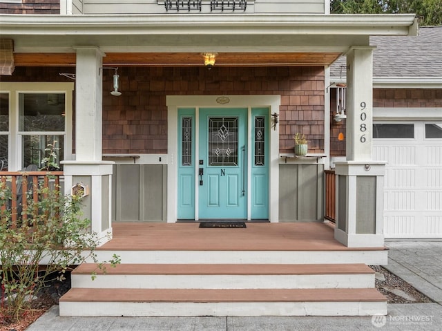 doorway to property with covered porch and a shingled roof