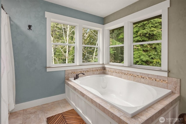 full bath with tile patterned floors, a garden tub, and baseboards