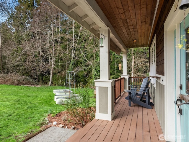 wooden terrace featuring covered porch and a yard