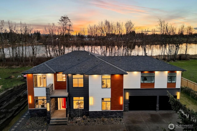 view of front of house featuring a garage, concrete driveway, roof with shingles, and stone siding