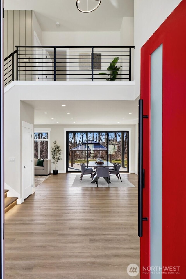 foyer entrance with recessed lighting, wood finished floors, a towering ceiling, baseboards, and stairway