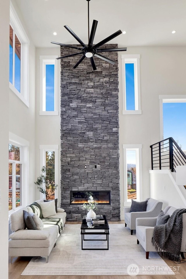 living room with a healthy amount of sunlight, a fireplace, and wood finished floors