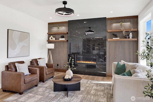 living room featuring wood finished floors, a high end fireplace, and recessed lighting