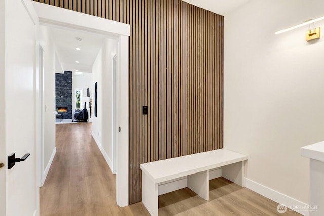 corridor featuring light wood-type flooring and baseboards