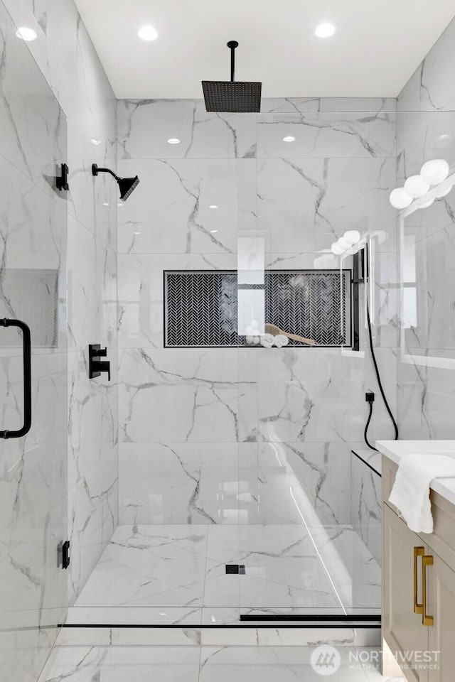 full bath featuring stone wall, a marble finish shower, vanity, and recessed lighting