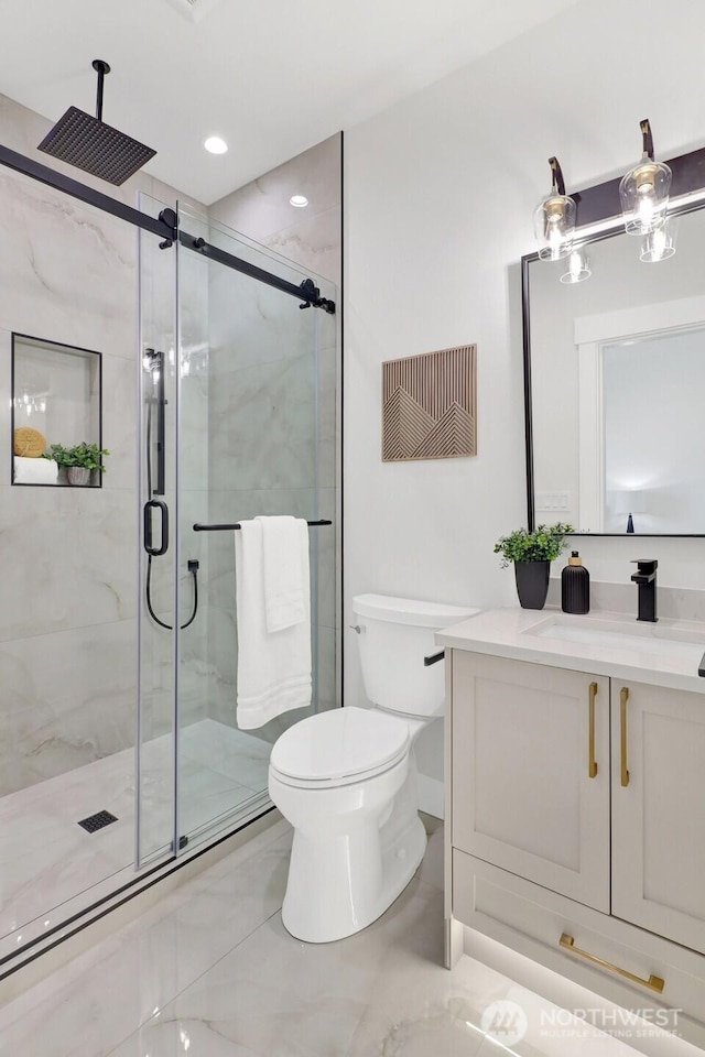 bathroom featuring a stall shower, vanity, toilet, and recessed lighting