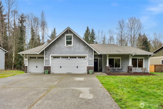 craftsman inspired home with a front yard, a garage, stone siding, and driveway