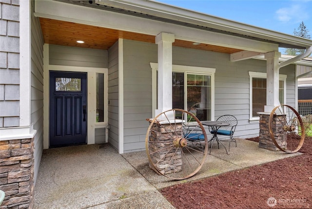 doorway to property featuring a patio area and stone siding