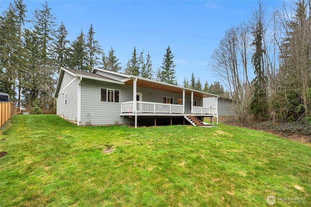 back of property featuring a deck, stairway, and a yard