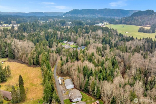 birds eye view of property with a mountain view and a view of trees