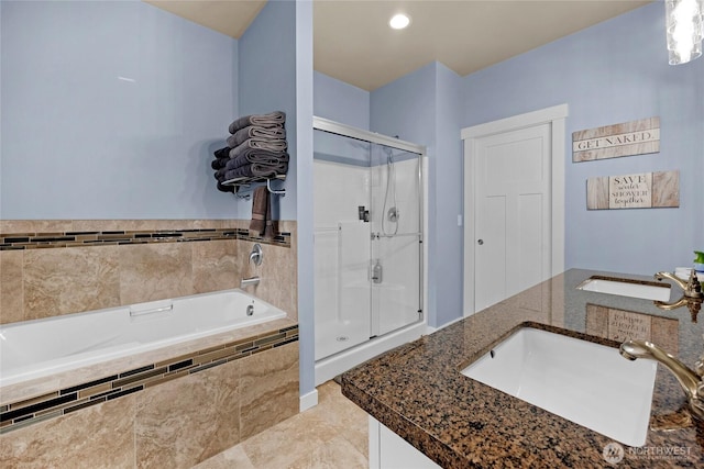 bathroom featuring tile patterned flooring, a garden tub, a stall shower, and a sink