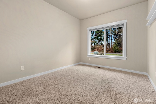 empty room with carpet flooring, visible vents, and baseboards