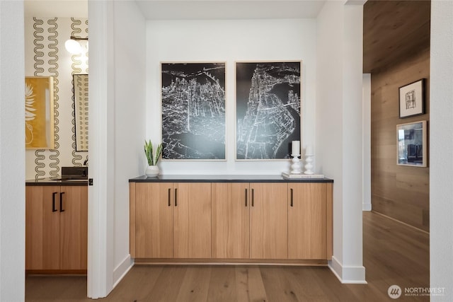 bar featuring baseboards and wood finished floors