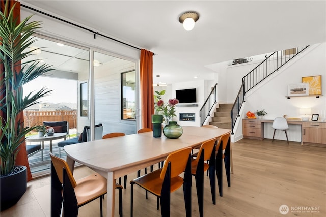 dining area featuring light wood-style flooring, stairway, and built in study area