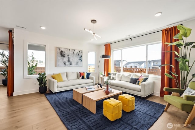 living room with light wood finished floors, recessed lighting, visible vents, and baseboards