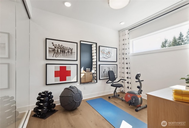 exercise room with baseboards, wood finished floors, and recessed lighting